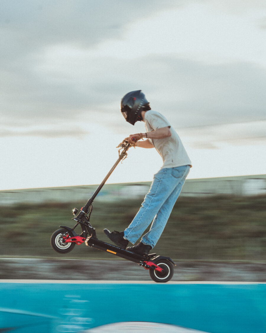 Pilote professionnel Kilian LARHER avec trottinette électrique MiniWalker 10 GTR rouge et noir en roue arrière